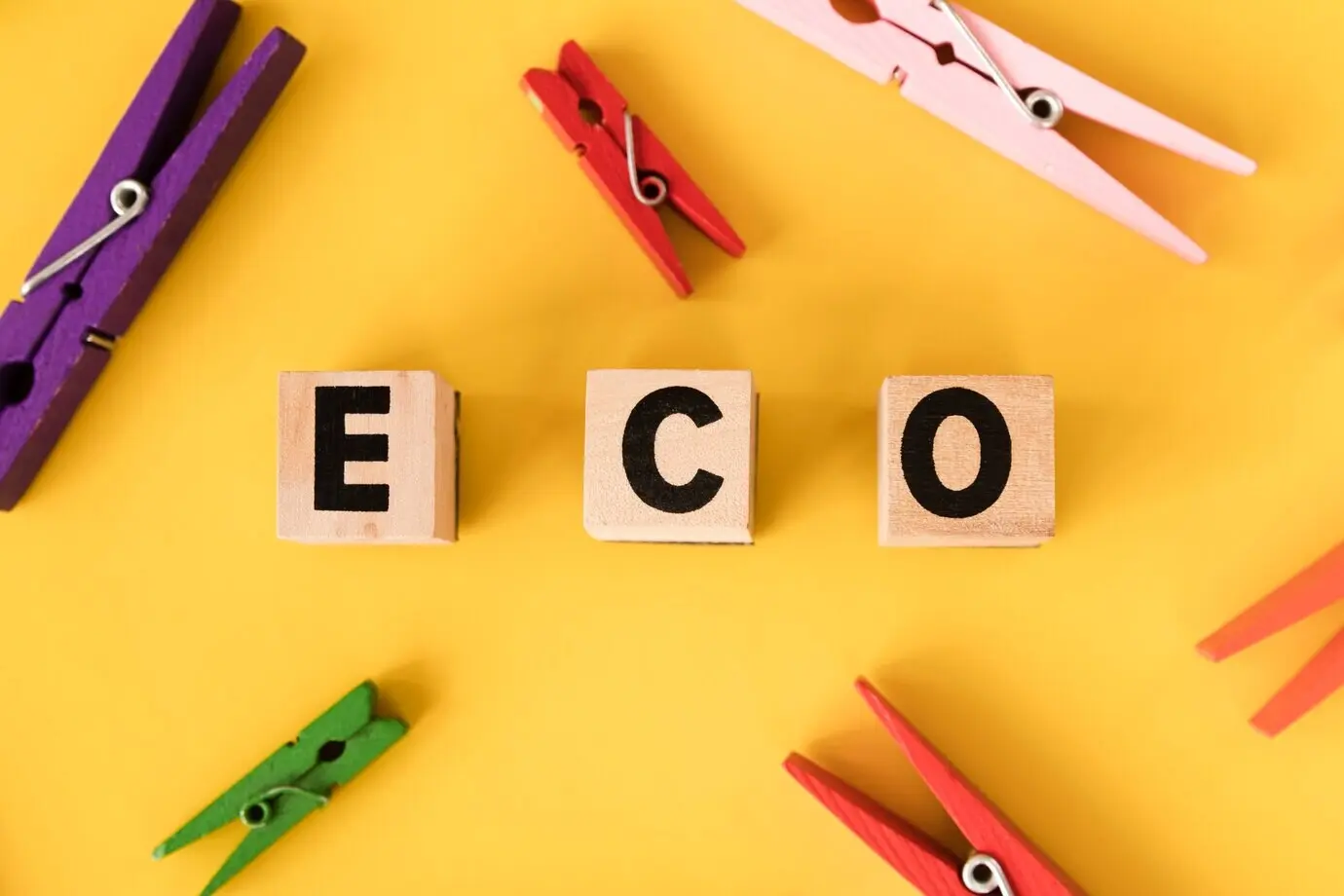 Draufsicht auf einen hölzernen Kleiderbügel vor gelbem Hintergrund.